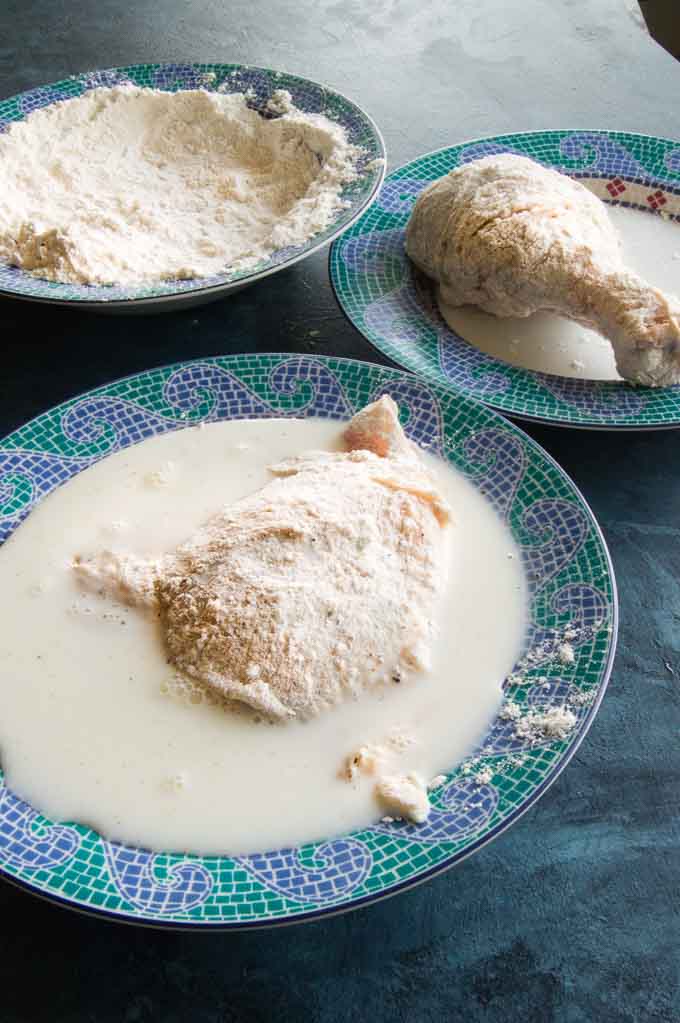 Dipping station for crispy fried chicken: seasoned flour, milk, resting plate