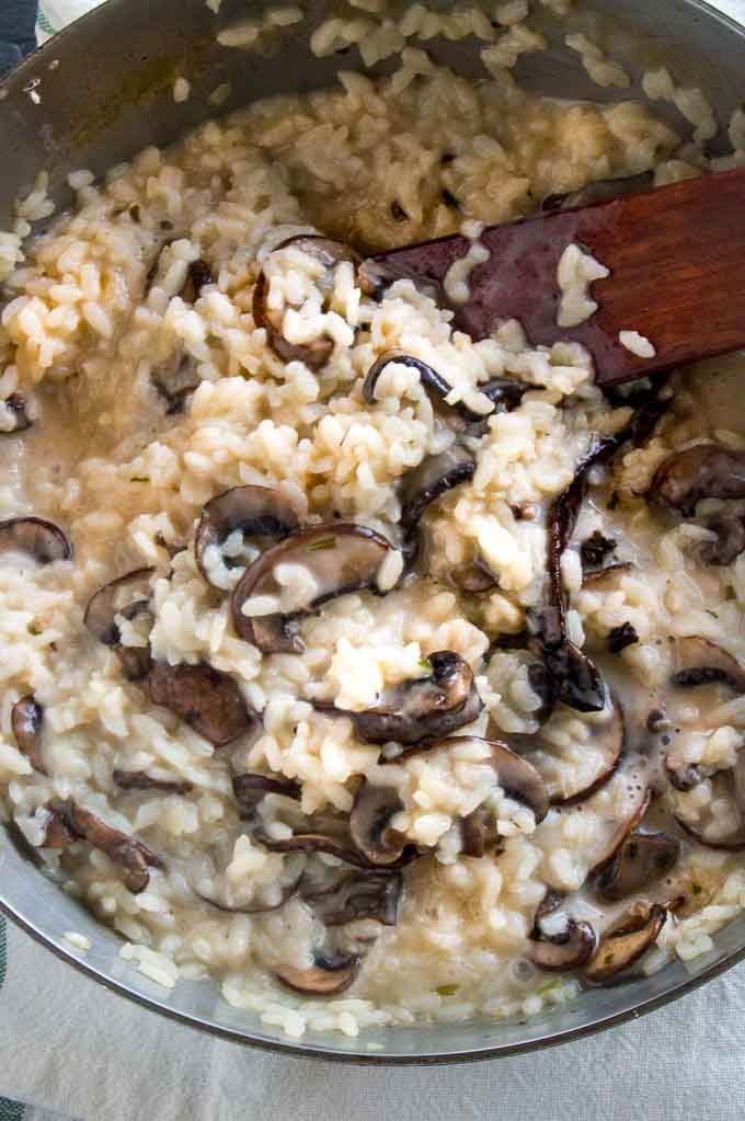 Adding mushrooms to the creamy mushroom risotto