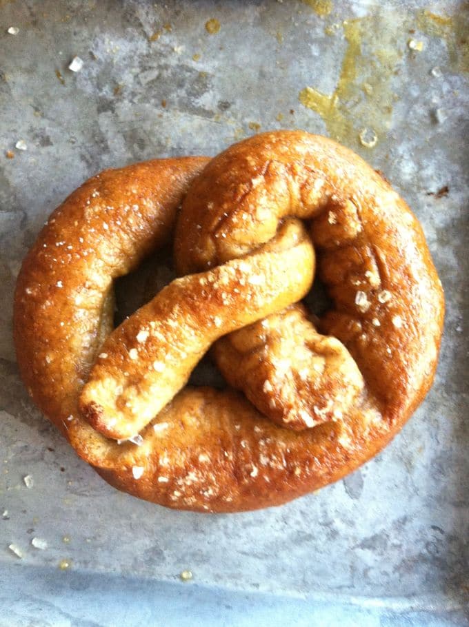Delicious homemade pretzel sprinkled with pretzel salt on a metal tray