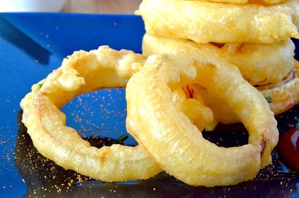 Better than at a restaurant, these Crunchy Fried Onion rings are light, airy and hold their crunchy without being greasy at all! Simple to make at home for an easy appetizer or as a side to go with a burger!