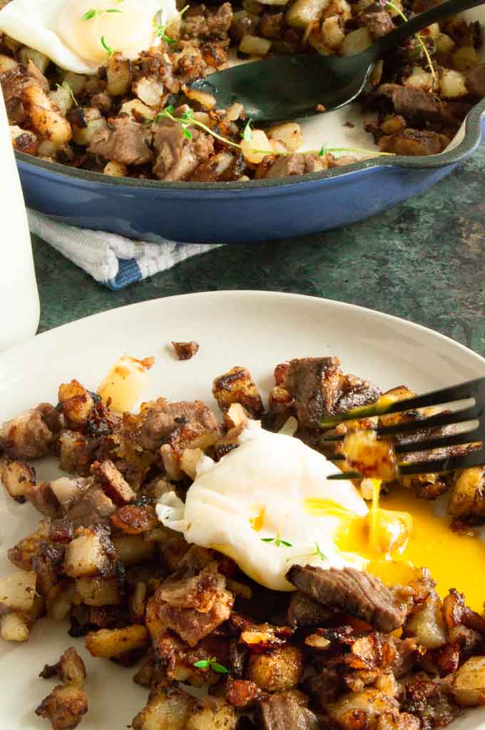 Cutting into an egg over potato breakfast hash.