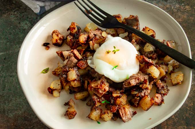 Individual serving of breakfast hash (potatoes, eggs, meat and onions)