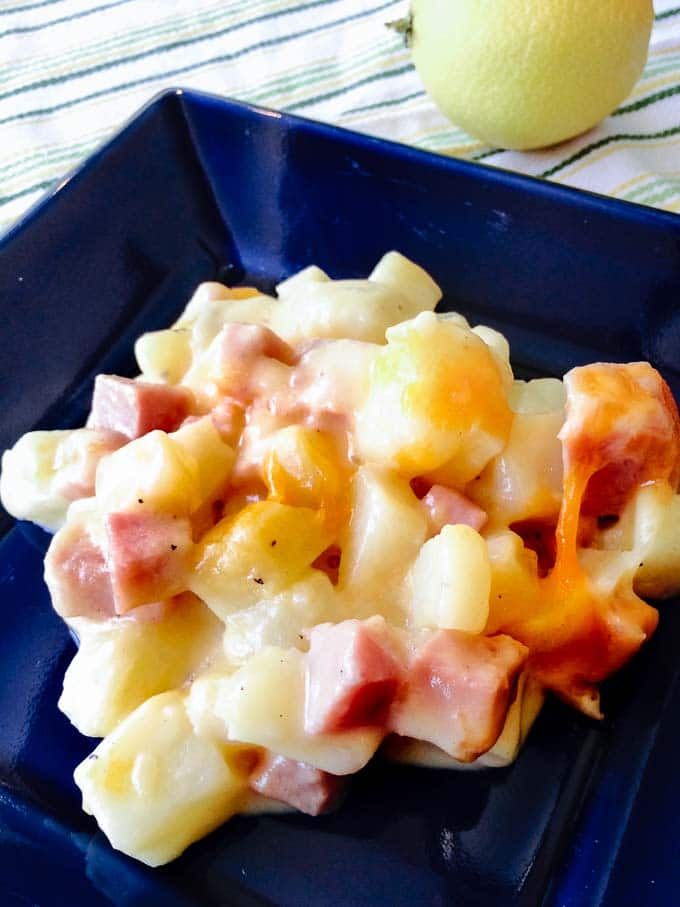 Cheesy ham and potato casserole on a blue plate