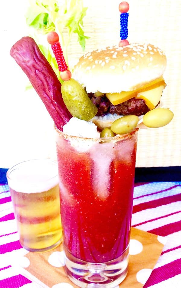 This Loaded Bloody Mary Cocktail is a full meal! Spicy Horseradish compliments the tangy tomato base and its topped with all the foods you want to eat when drinking a Bloody Mary, a burger, beef stick, olives, chunks of cheese and a Celery Stalk! Perfect for a brunch or watching a game!