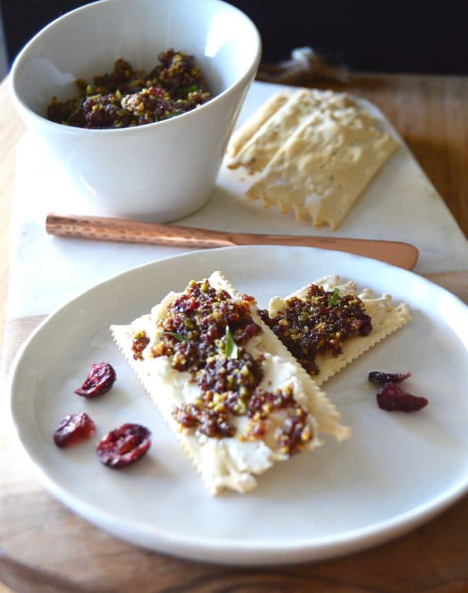 Cranberry Pistacio Spread on crackers next to a bowl of extra spread!