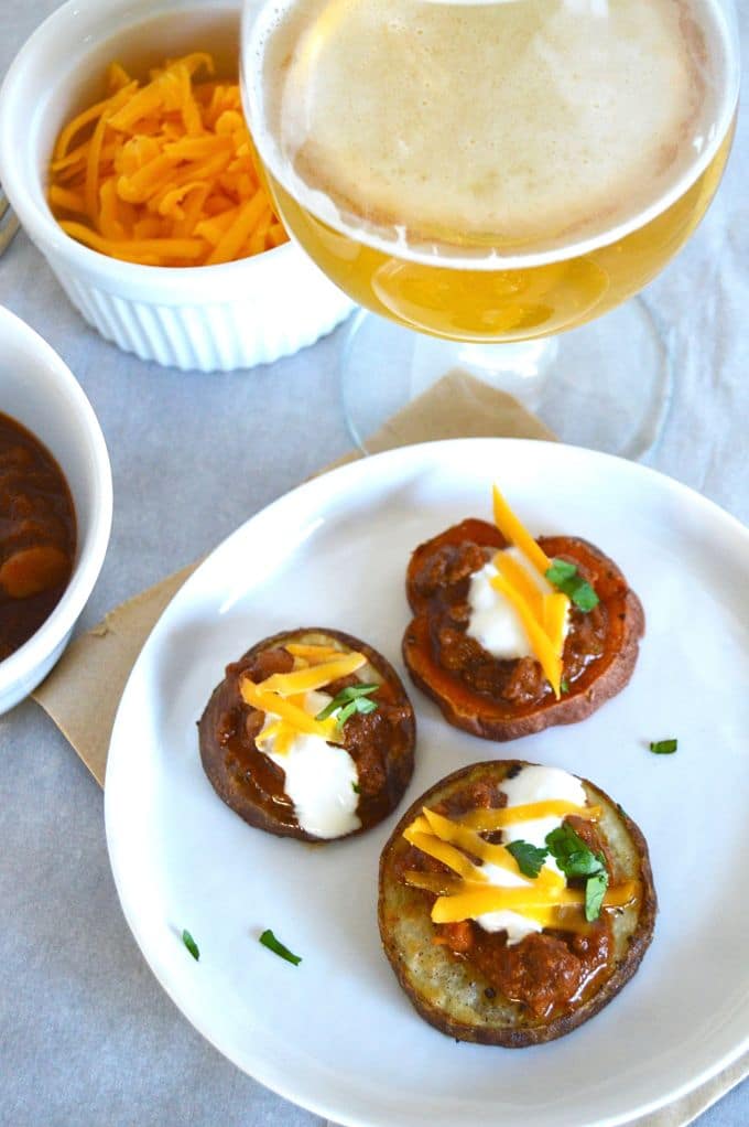 Small, one-bite appetizers for a small get together. This recipe for Smokey Chili Potato Bites has chili topped with cheese served over a crisp baked potato wedge with a cool creamy Chobani yogurt dollop.
