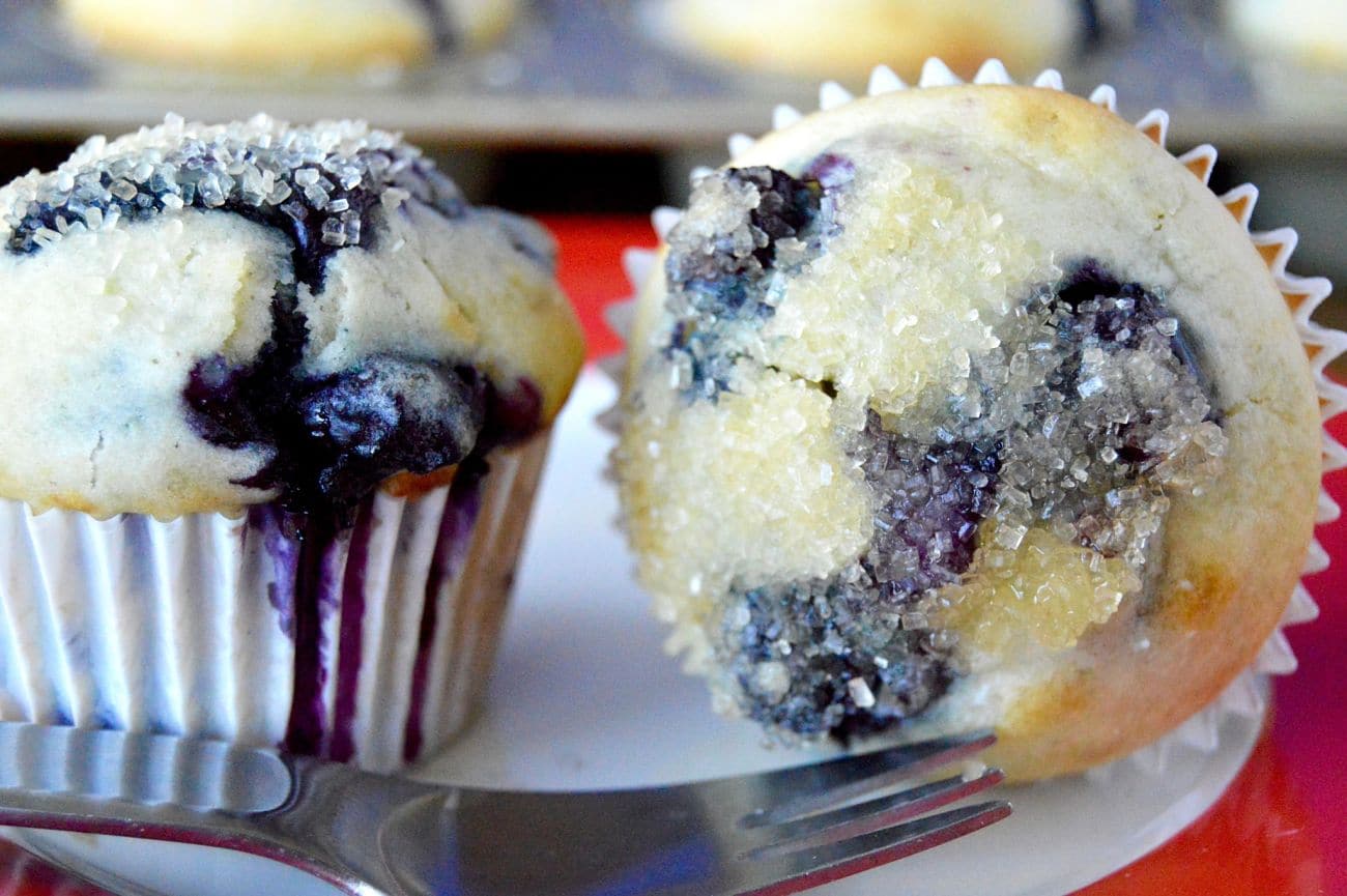 Lemon Scented Blueberry Muffins are moist on the inside, packed full of juicy blueberries in every bite. The top is crunchy and glazed with hints of lemon butter and lastly sprinkled with sugar. Perfect for taking on the go, getting together with friends or to serve at a morning meeting.
