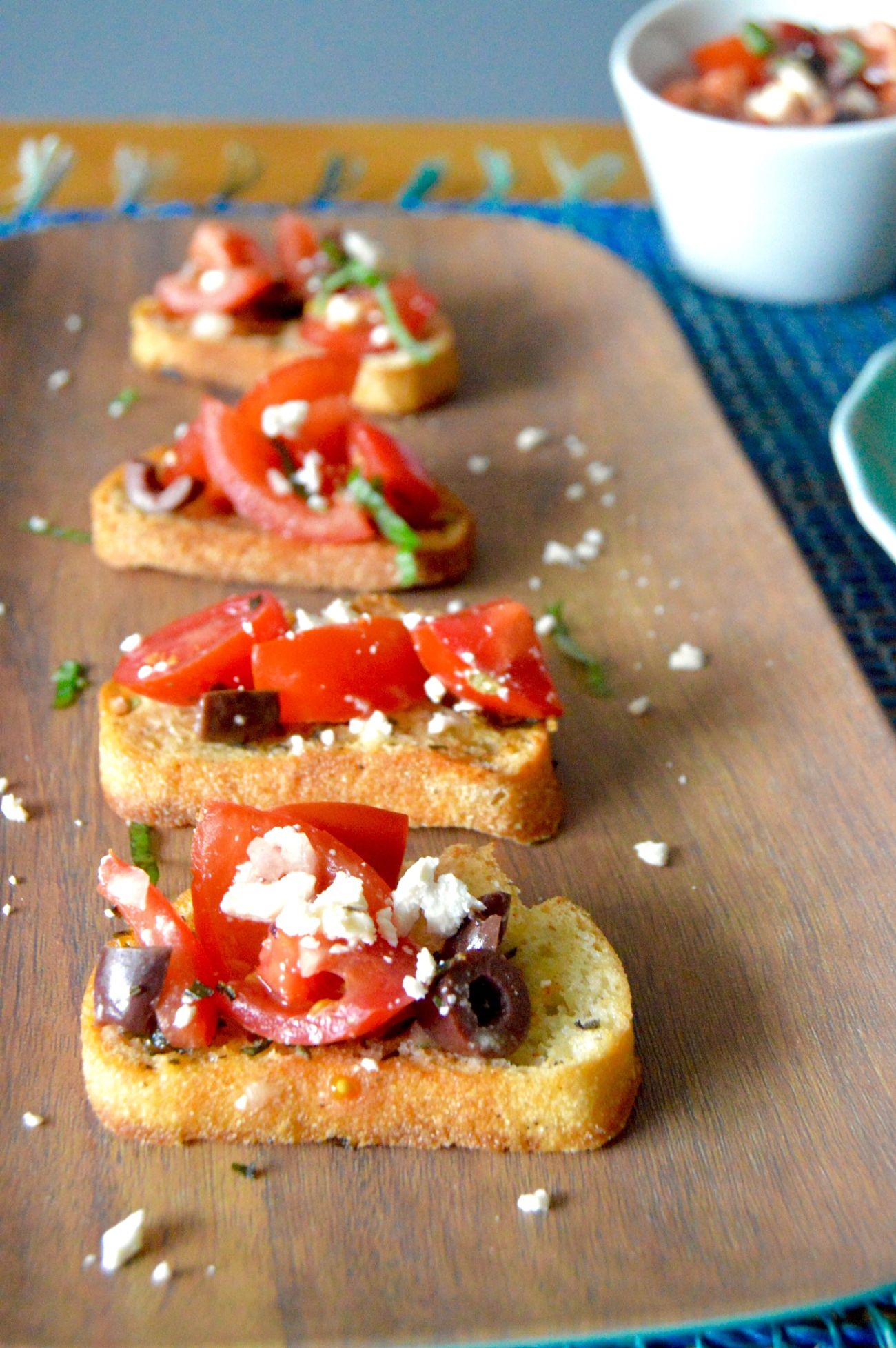 This recipe for Feta Kalamata Bruschetta (aka Greek Style) can be made no time at all and is packed with flavor. Creamy Feta, sweet, juicy tomatoes with just the right amount of salty kalamata olives! Put on top of your favorite toast or serve it alone as a simple salad!