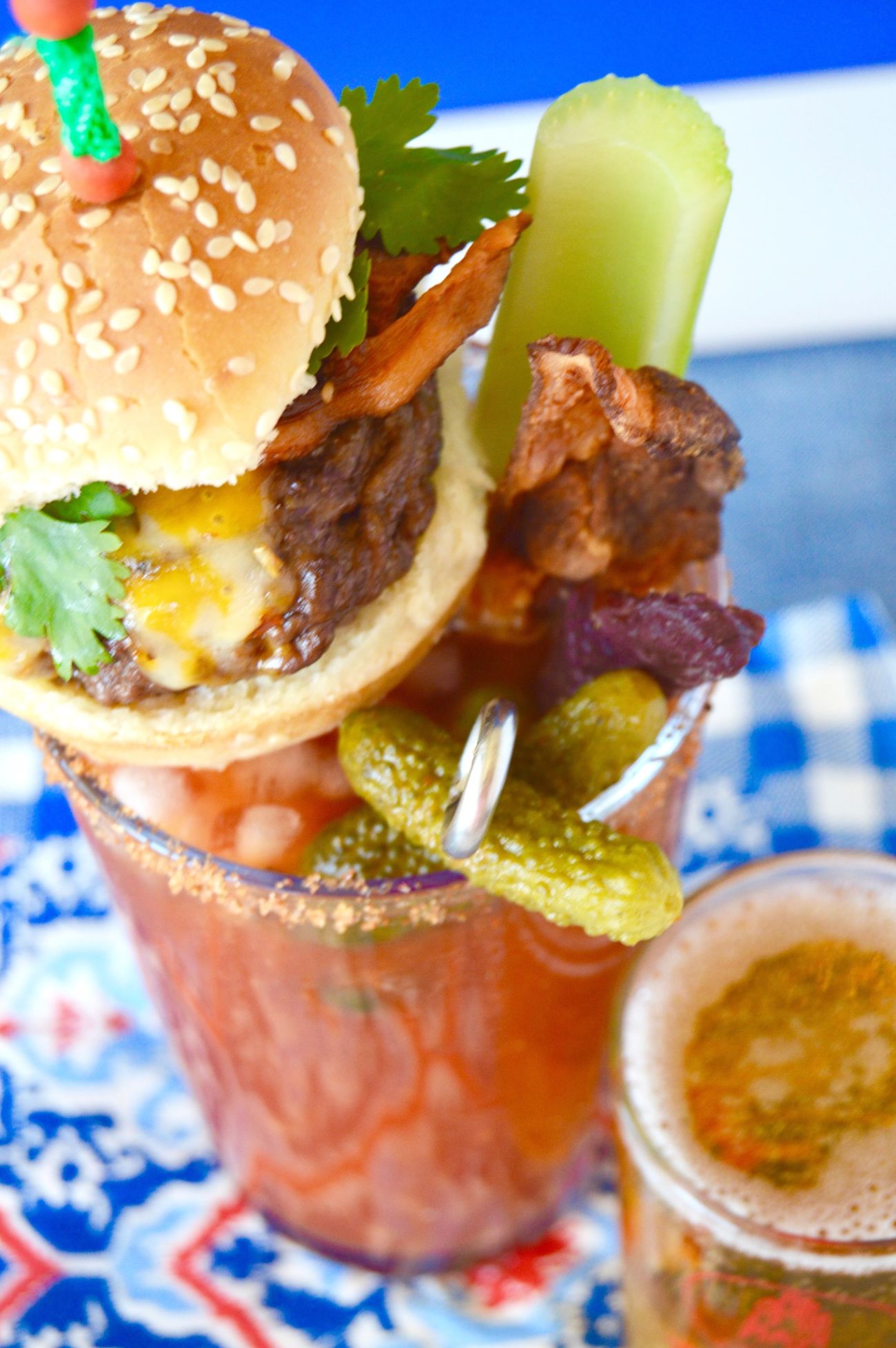 This Loaded Bloody Mary Cocktail is a full meal! Spicy Horseradish compliments the tangy tomato base and its topped with all the foods you want to eat when drinking a Bloody Mary, a burger, beef stick, olives, chunks of cheese and a Celery Stalk! Perfect for a brunch or watching a game!