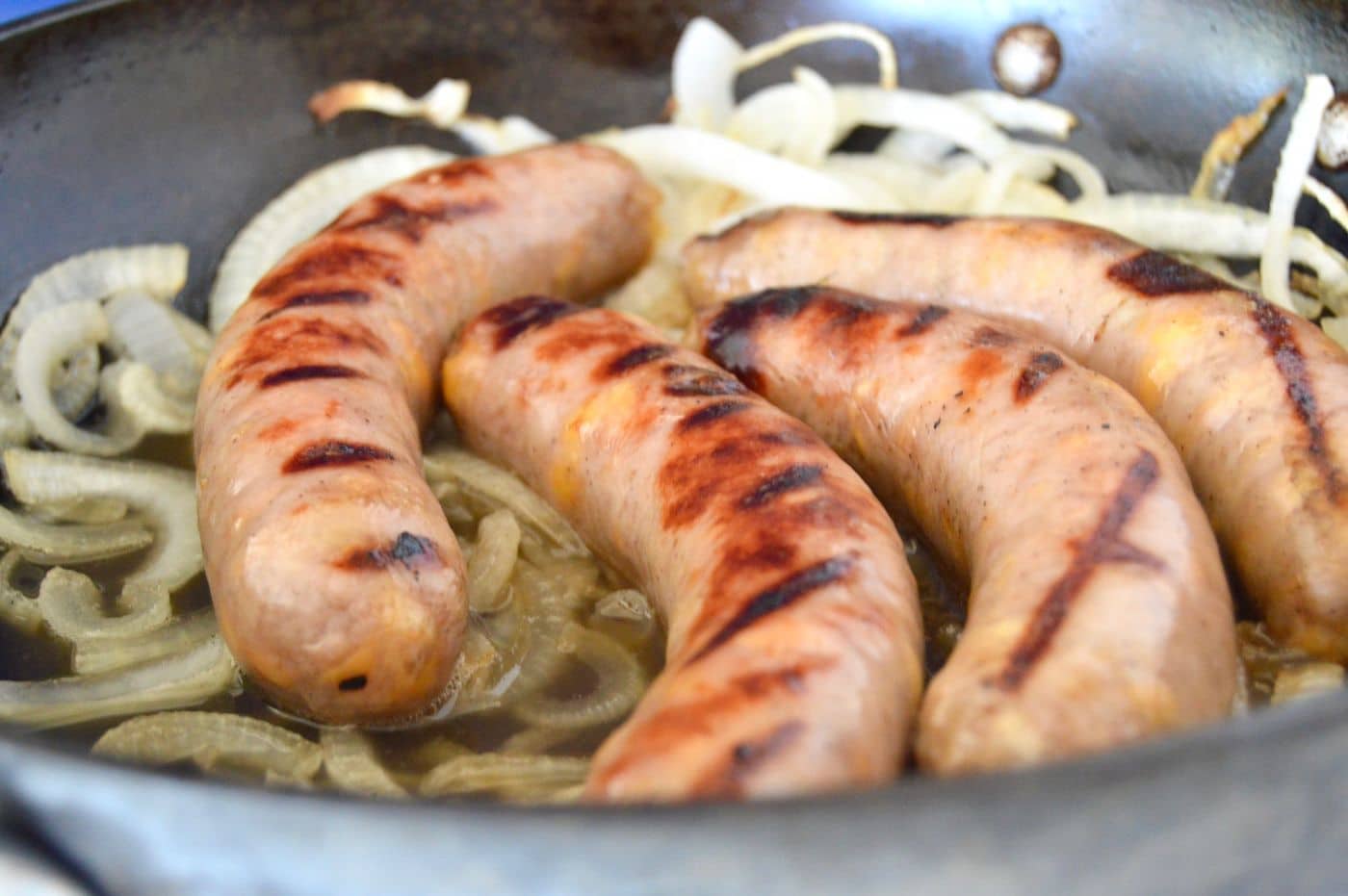brats in a pan with onions