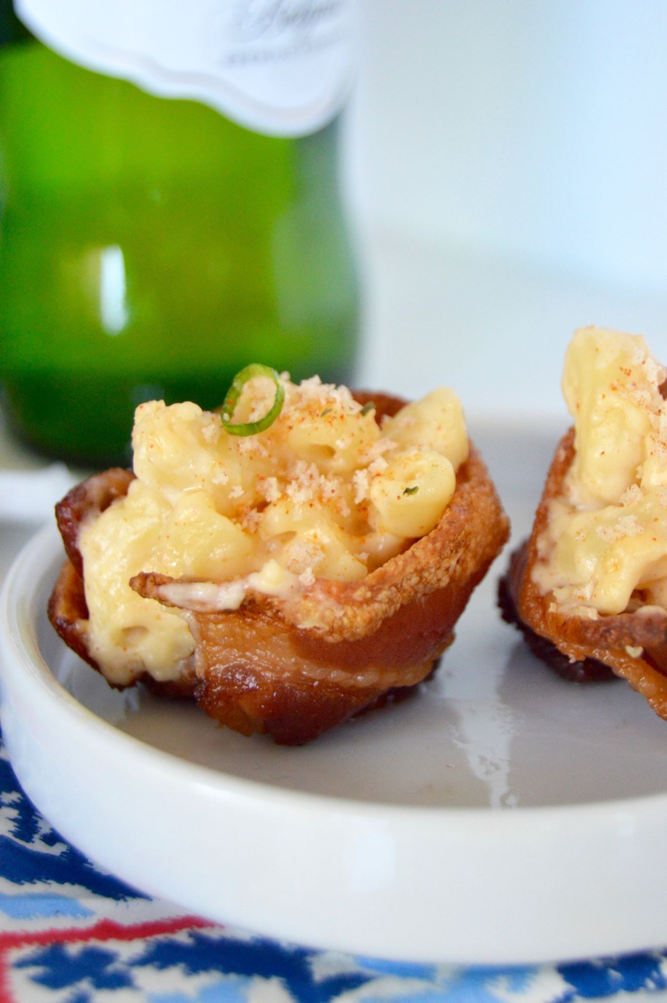 Small cups made of bacon stuffed with macaroni and cheese on a plate