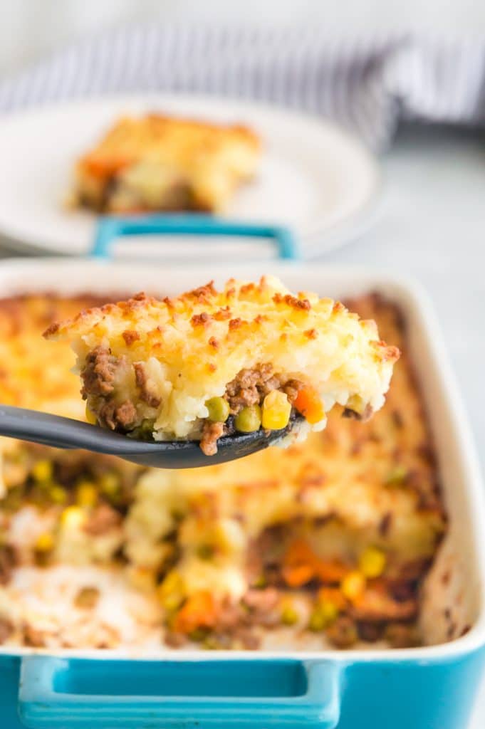 spoonful of ground beef casserole over the tray it was made in