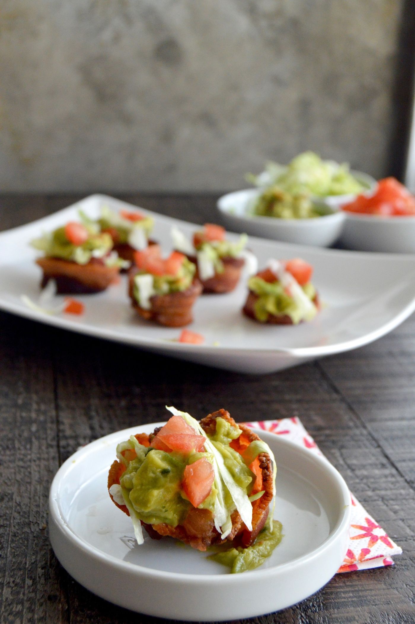 Guacamole BLT Bacon Cups are a low carb appetizer or snack that can be made in about 15 minutes. Crisp lettuce, juicy tomatoes a dollop of Guacamole all in a bite sized crispy bacon cup! 