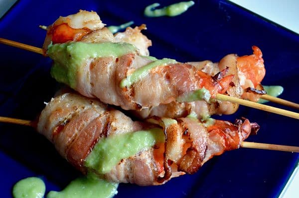 These Bacon Wrapped Shrimp with Avocado dip are 3 bite appetizers that will go quickly at any party! Succulent shrimp, wrapped in bacon broiled to perfection then served on skewers with a healthy avocado salsa! |appetizer|happy hour| Bacon|Superbowl party|