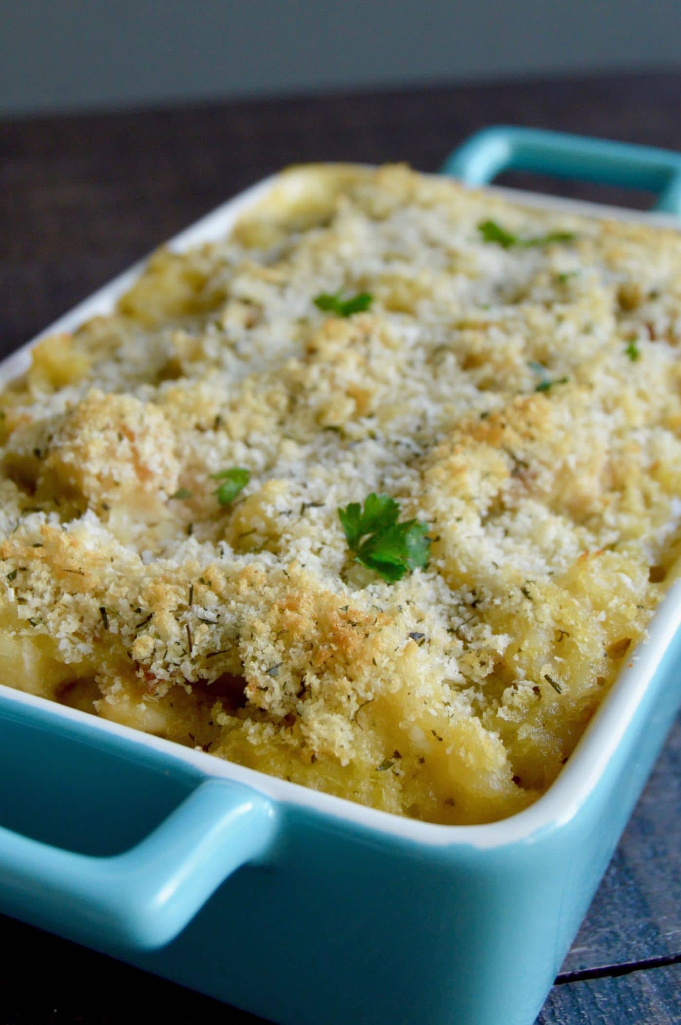 Cheesy Chicken Artichoke Casserole in a turquoise baking dish on a table
