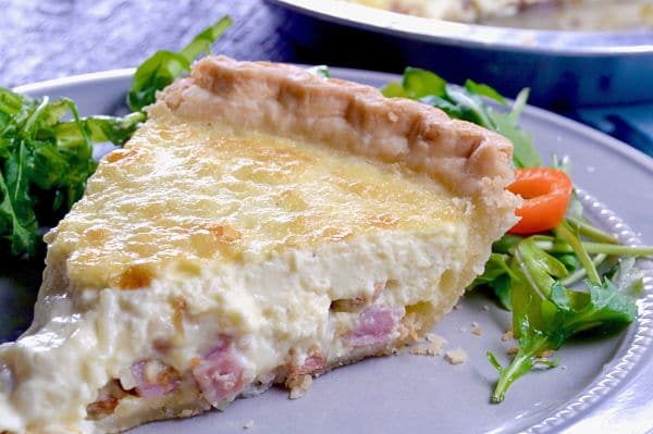 No Fail Quiche Lorraine, an easy yet impressive recipe full of melty cheese, crisped bacon and ham mixed in a light creamy custard in a flaky buttery crust.