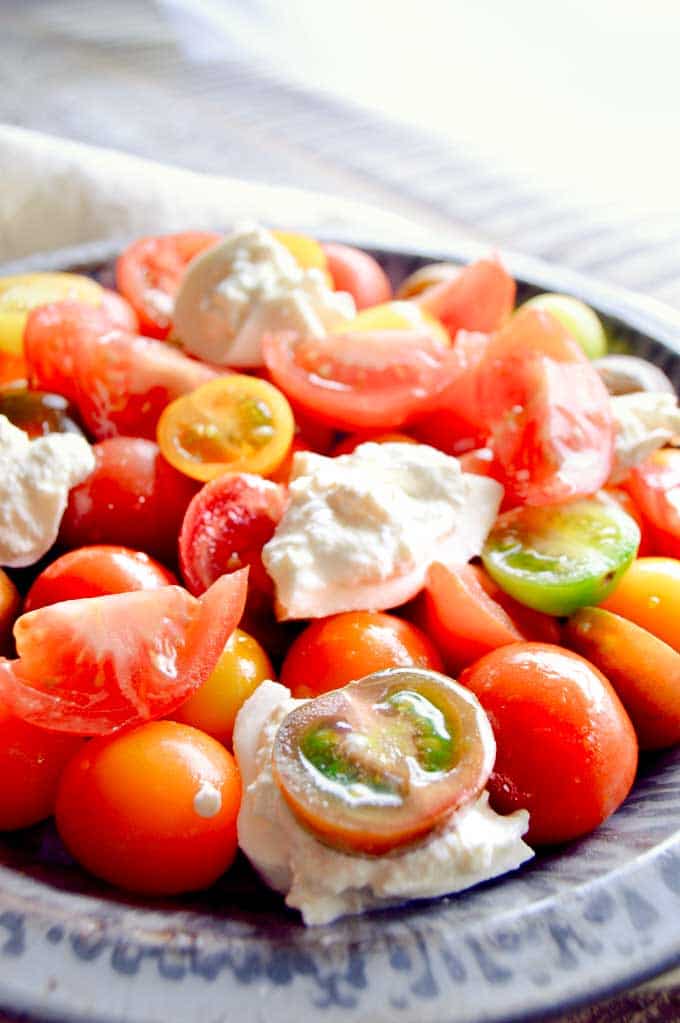 plate of tomato salad with fresh burrata on top