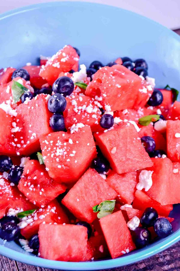 turquoise bowl with watermelon chunks and blueberries in it