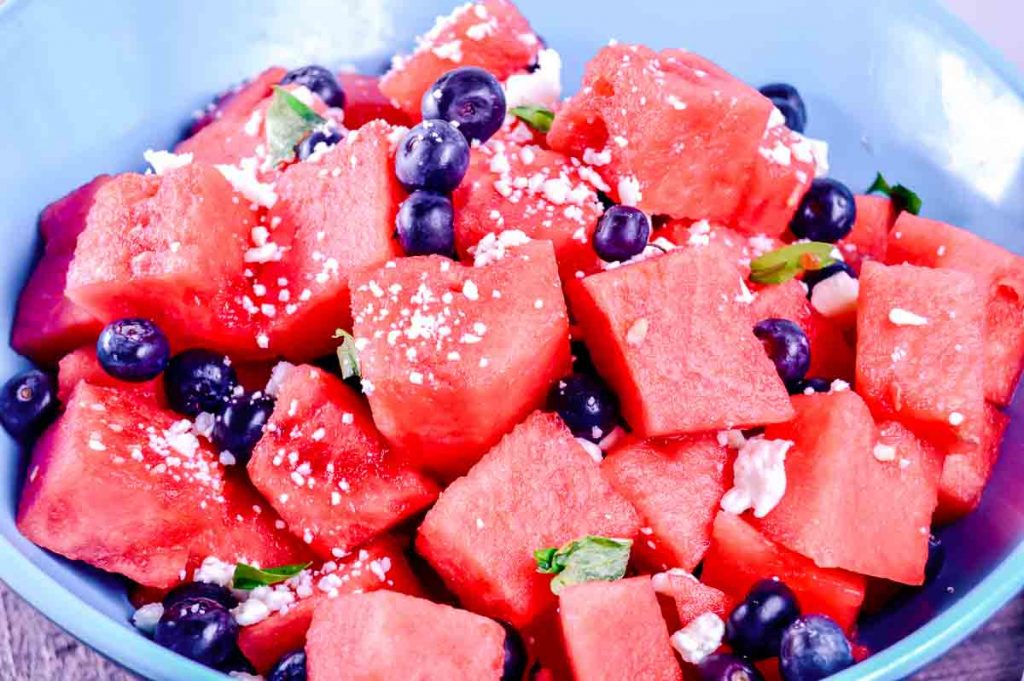 feta, watermelon, blueberry and basil salad in a blue bowl