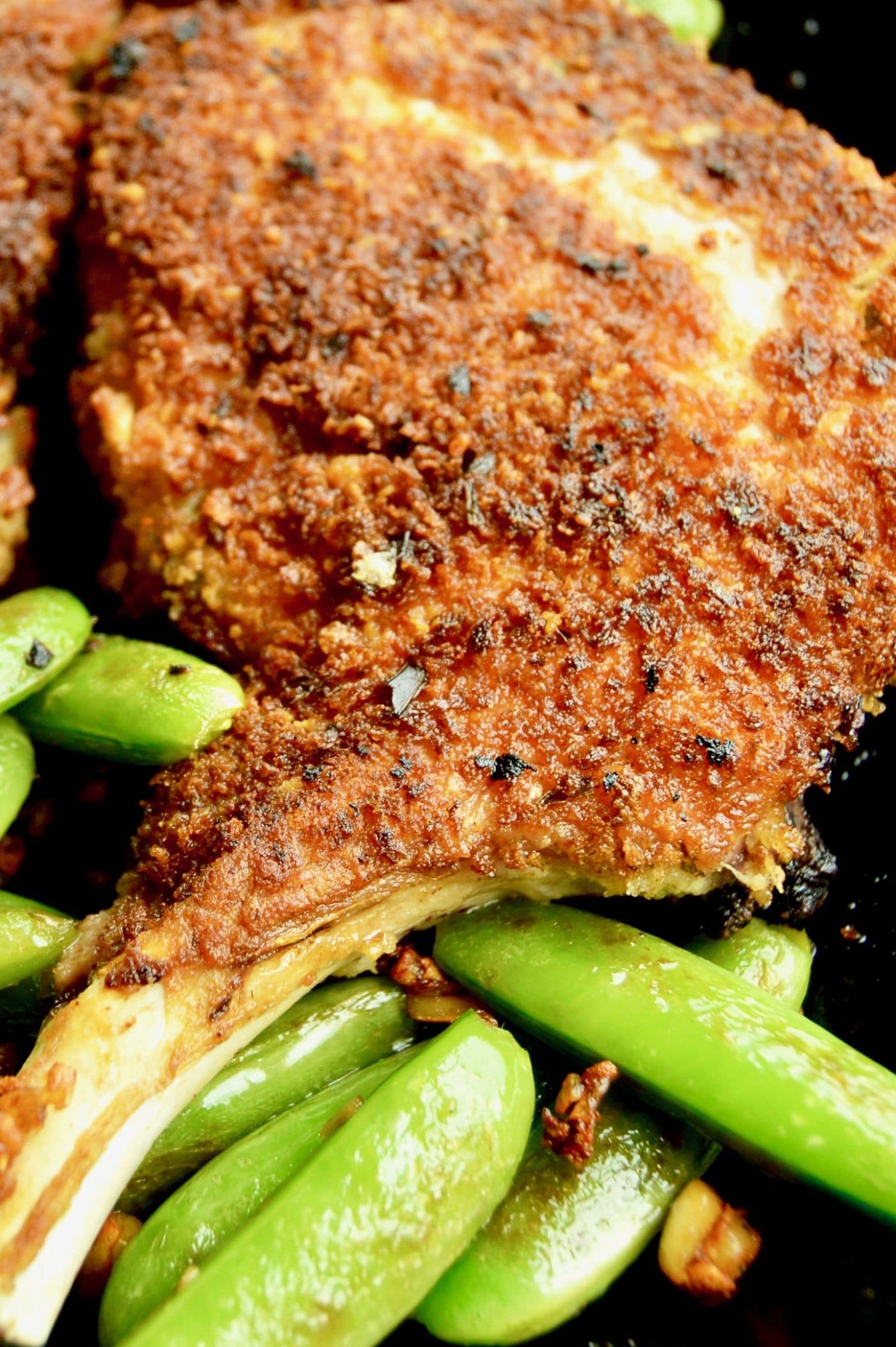 Pork Chops coated in Panko and Parmesan served in a cast iron skillet with sugar snap peas!