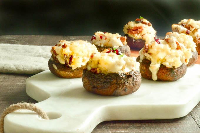 Serving platter of stuffed mushrooms caps with cheesy rice and cranberries