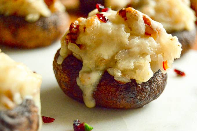 This Cheesy Rice Stuffed Mushrooms Recipe is great for a side dish or ideal for entertaining as an appetizer! Elegant gourmet bite sized servings make them a go to recipe for any occasion!