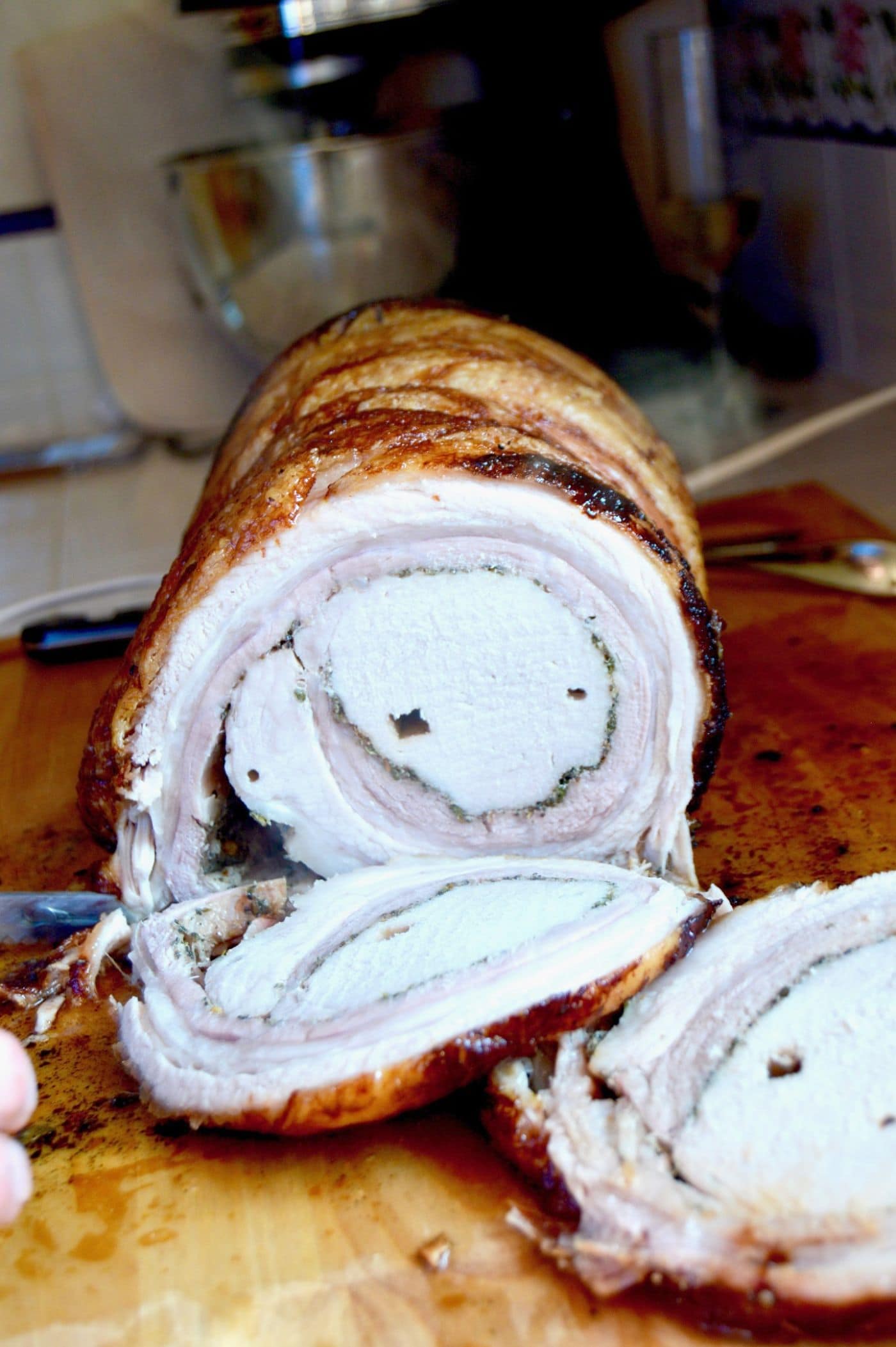 Slices of the pork belly roll---Porchetta, Crispy Pork Belly with herbs wrapped around a pork tenderloin and cooked to juicy, tender perfection.  A crazy impressive meal to your guests, but you'll know how simple it was to make!