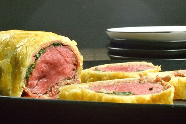 Beef Wellington Puff pastry appetizers. Shown on a plate with them half of them cut and ready to eat.