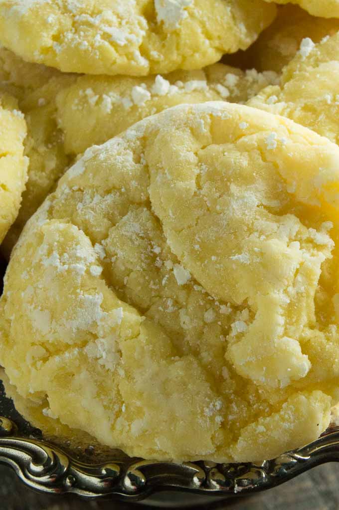 Closeup of the lemon gooey butter cookies showing the crinkle in the cookie and powdered sugar