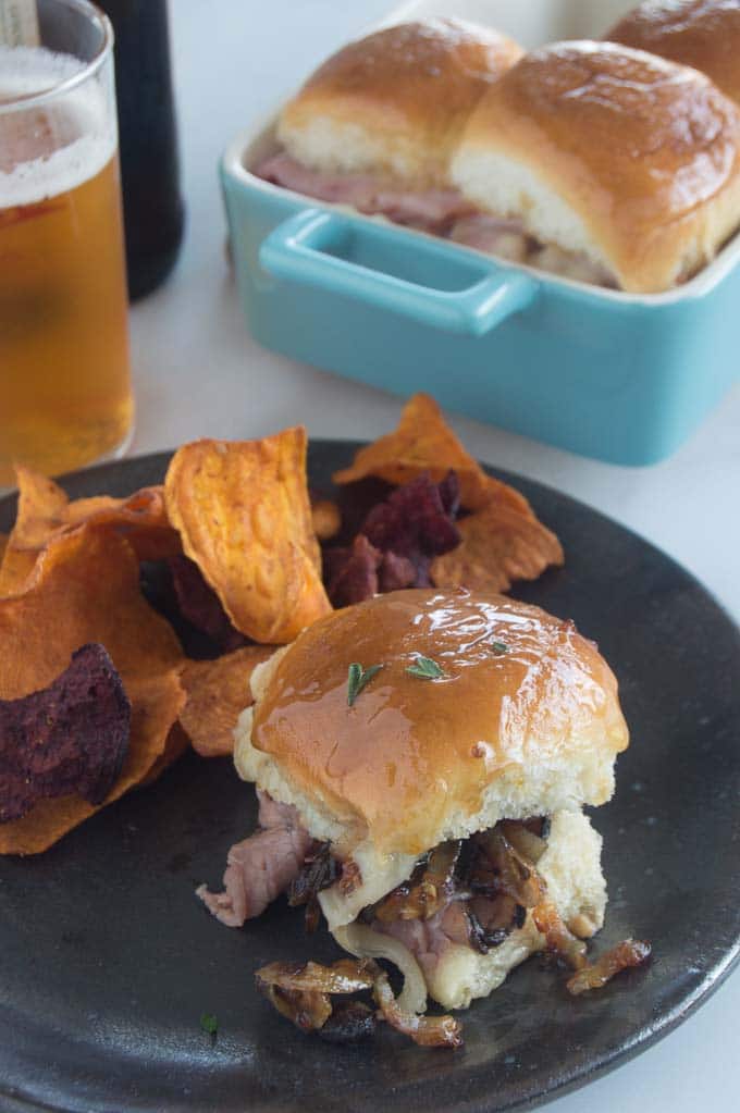 Individual roast Beef slider on a plate with chips being served at a game day party