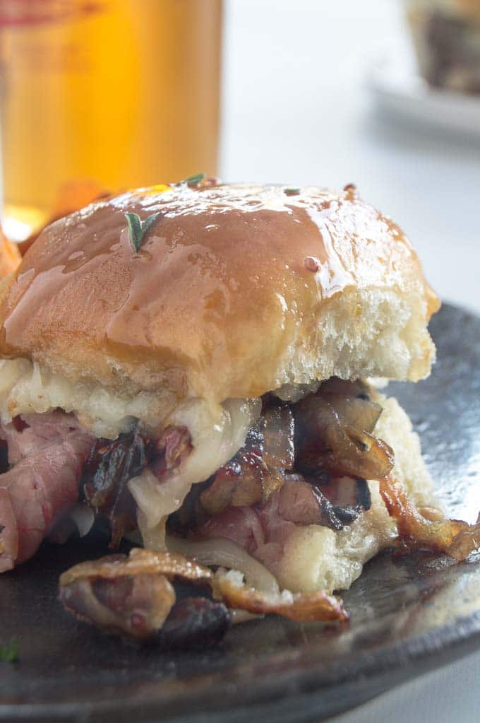 Close up of a melty cheese and onion laden roast beef slider