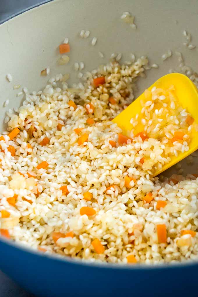 Heating Risotto and carrots until the rice is clear around the edges