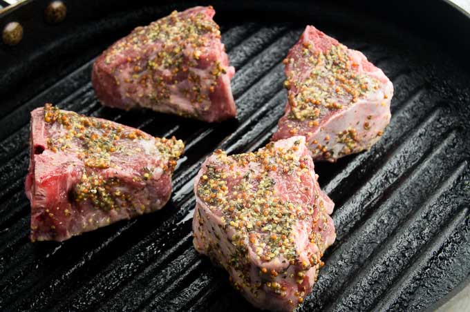 Mediterranean herbs and spices coat Loin lamb chops in pan