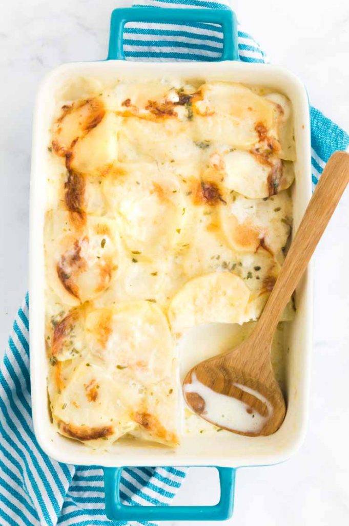 Serving dish with creamy scalloped potatoes with lots of sauce