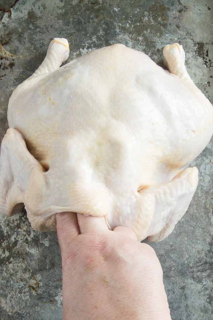 Sliding fingers into all areas between all parts of chicken to create a pocket.