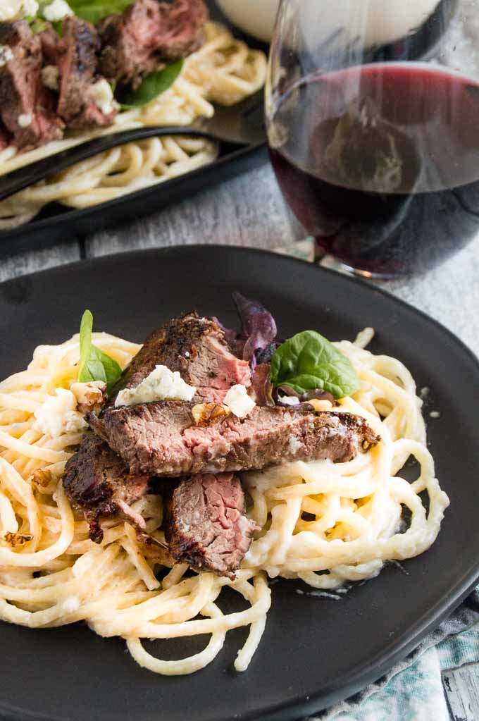 Individual Portion of Blue Cheese pasta with steak atop.