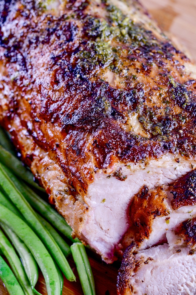 sliced mojo pork on a tray with green beans
