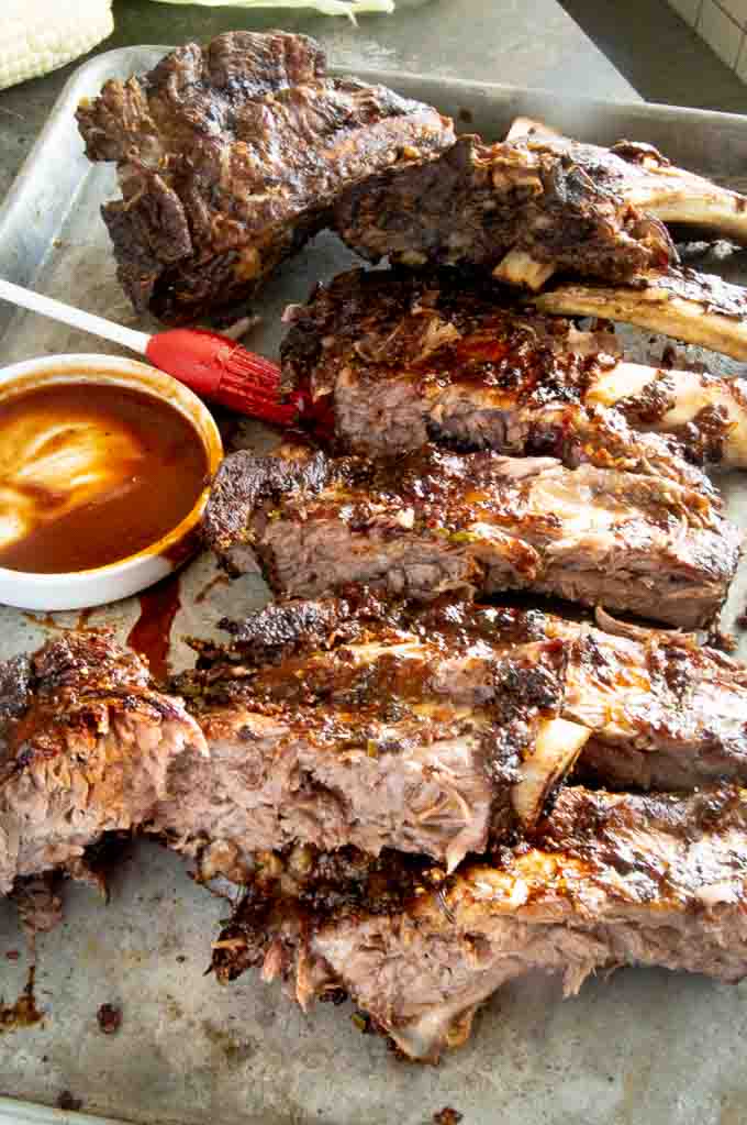 Tender fall off the bone Beef ribs cut into single ribs on a silver tray