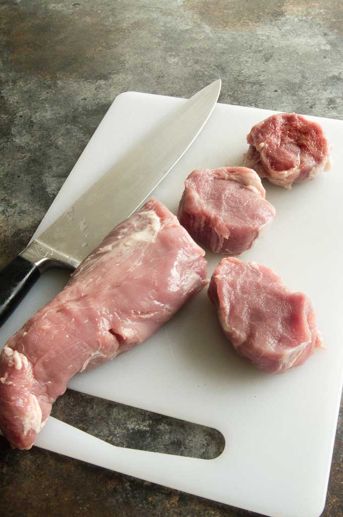 Cutting the pork tenderloin to medallions.