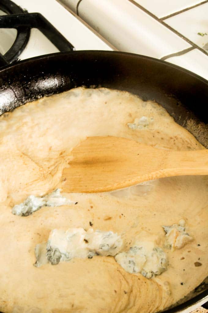 Blue cheese being added for cream sauce