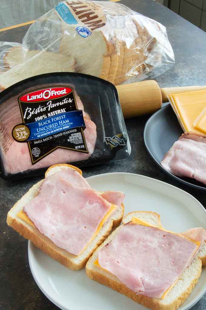 Preparing ham and cheese slices on the bread