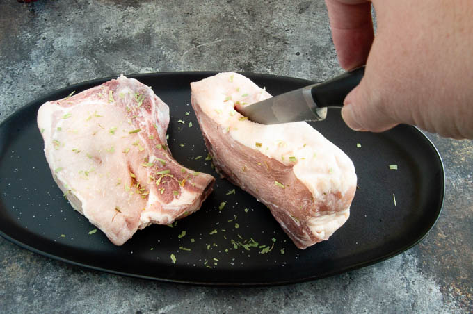 Showing a 2" cut to create a pocket to make baked stuffed pork chops