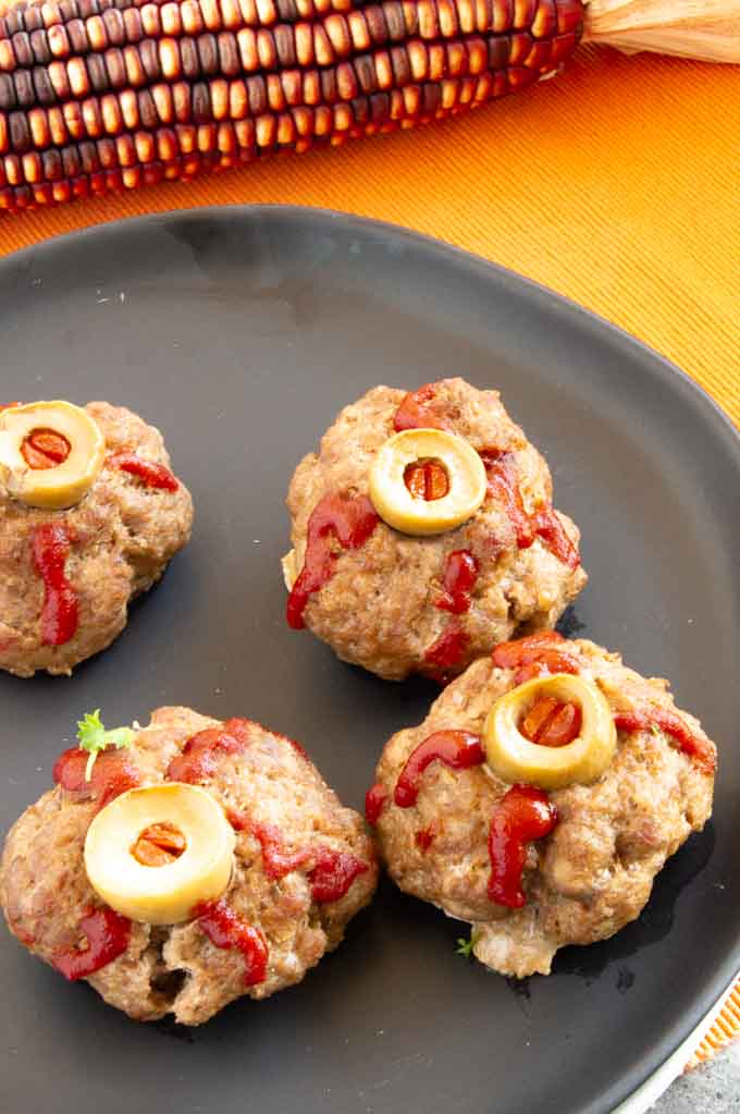 meatballs on a plate with olives for eyes "eyeball meatballs for halloween"