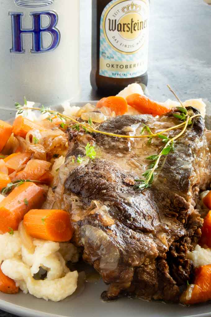 Serving platter with Sauerbraten Pot Roast on a plate with spaetzel and carrots