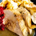 Close up of thanksgiving dinner plate with turkey, mashed potatoes and cranberries
