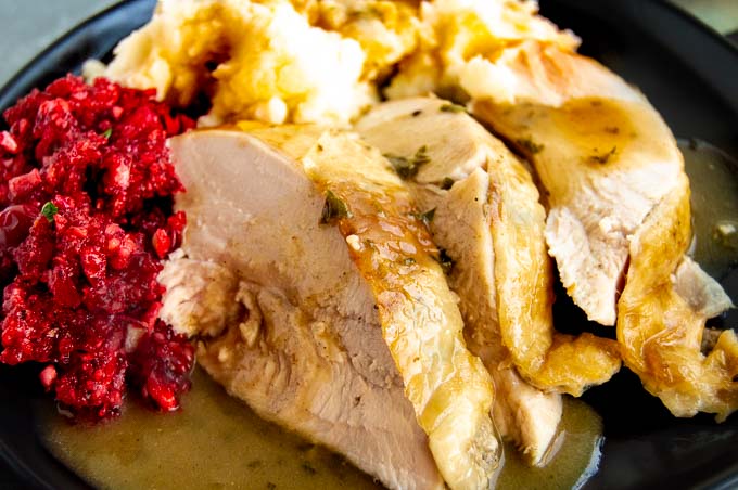 Close up of thanksgiving dinner plate with turkey, mashed potatoes and cranberries