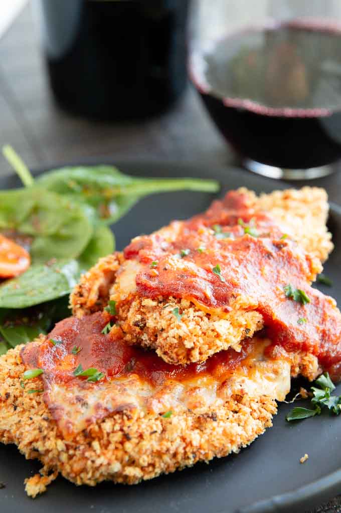 two crispy chicken parmesan pieces on a plate