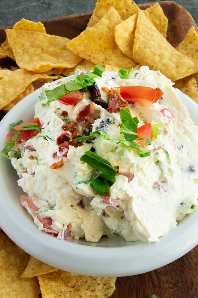 BLT dip in a bowl with chips surrounding it.