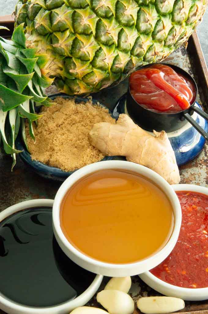 Ingredients for Hawaiian BBQ sauce on a platter. Ginger, Sugar, Ketchup, Soy Sauce, Garli and vinegar.