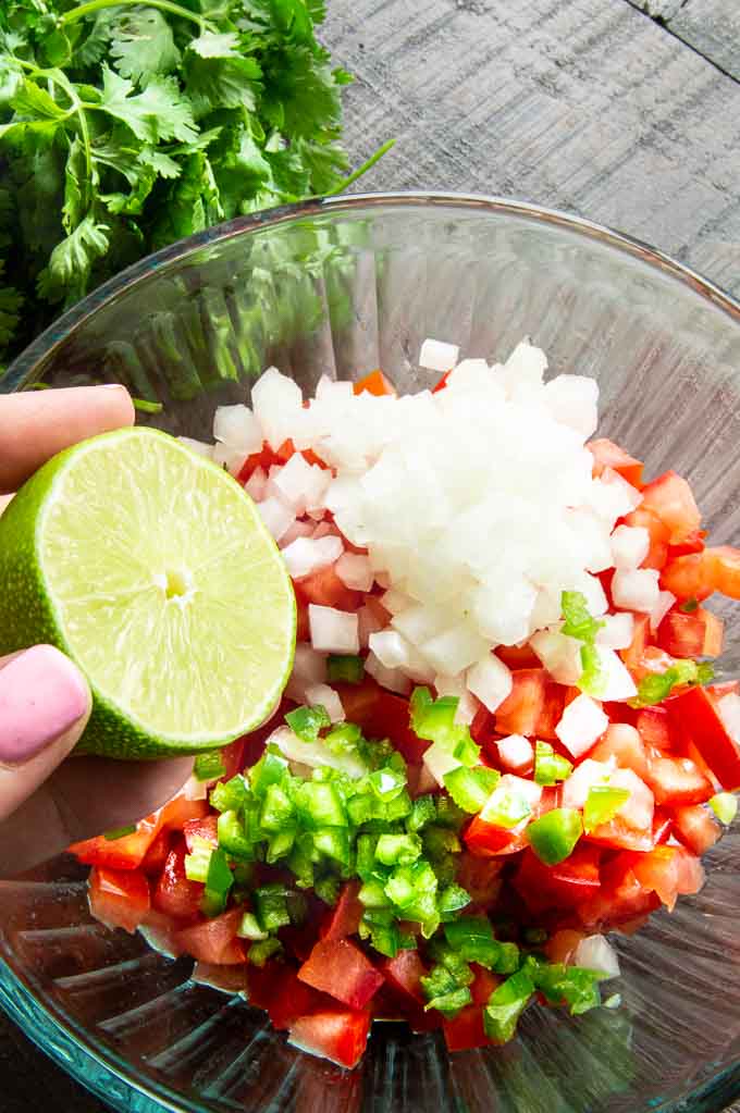 fresh lime juice being squeezed of pico de Gallo
